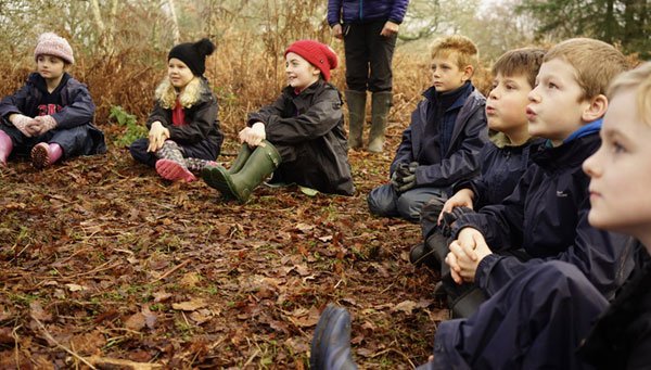 Children apart of the Children's Forest gathered in a circle learning about the importance of nature